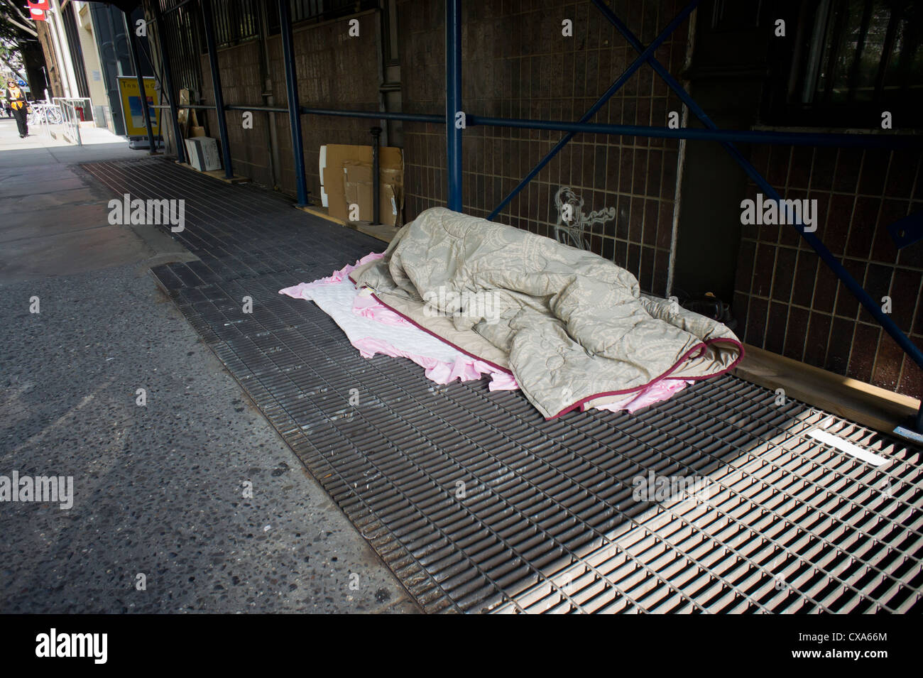 homeless-man-sleeping-on-a-vent-in-the-sidewalk-in-greenwich-village-CXA66M.jpg