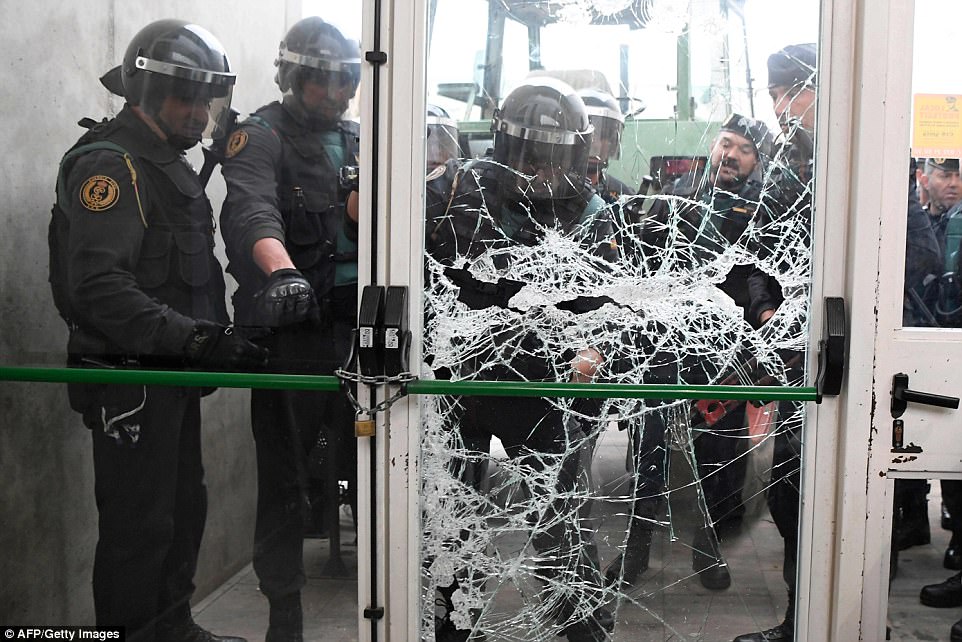 44E958DF00000578-4937860-Spanish_Guardia_Civil_officers_smash_down_the_door_of_a_polling_-a-50_1506847425665.jpg