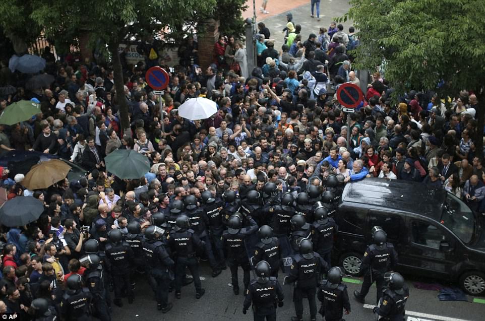 44E9662B00000578-4937860-Spanish_National_Police_prevents_people_from_entering_a_voting_s-a-55_1506847425759.jpg