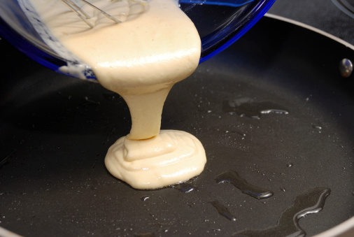 pouring-pancake-batter-in-a-hot-frying-pan-picture-id172897088